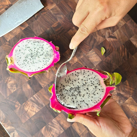large spoon scooping out an entire half of dragon fruit to remove the peel