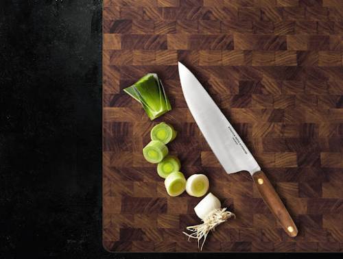 knife and chopped vegetables on a black walnut cutting board