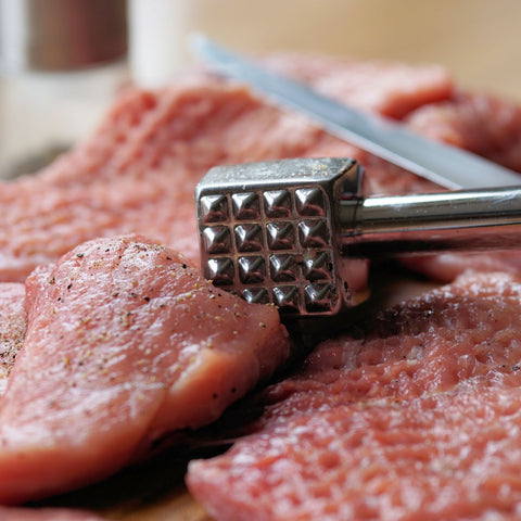 mallet beating a eye round steak