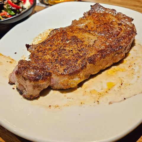 Seared ribeye steak resting on plate