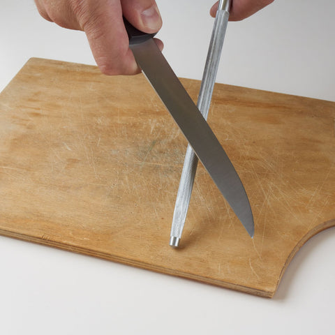 sharpening a serrated knife over a rod
