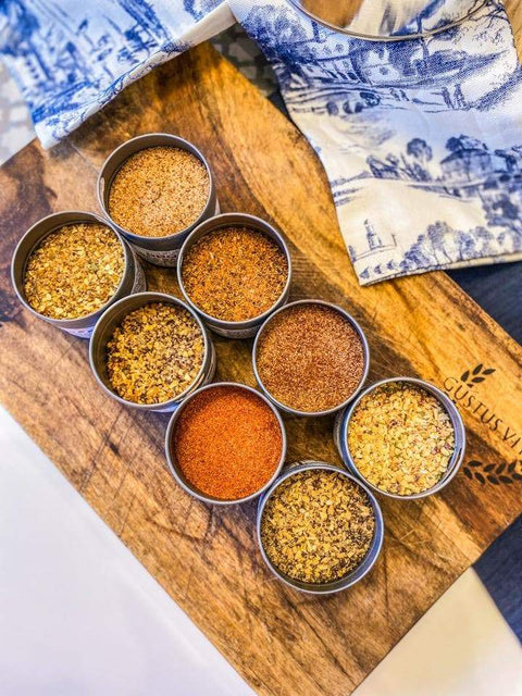 top view of different seasonings by gustus vitae arranged on a wood cutting board