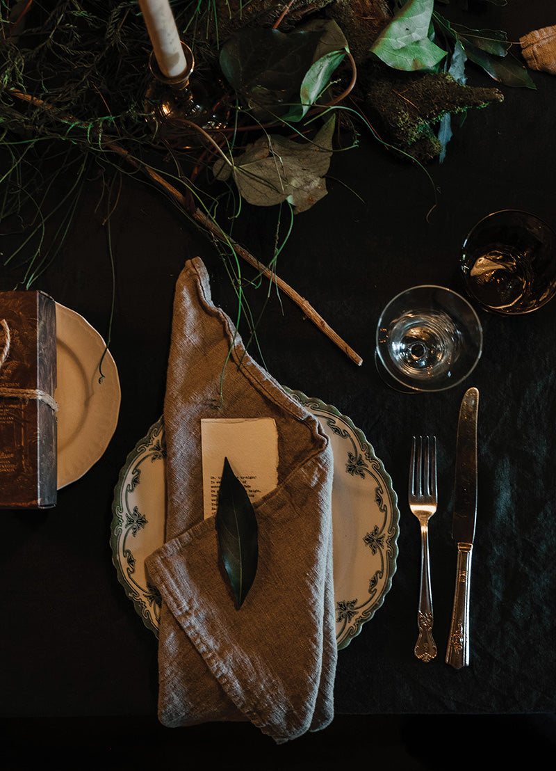 A vintage themed festive table with pine, ivy and brass candlesticks