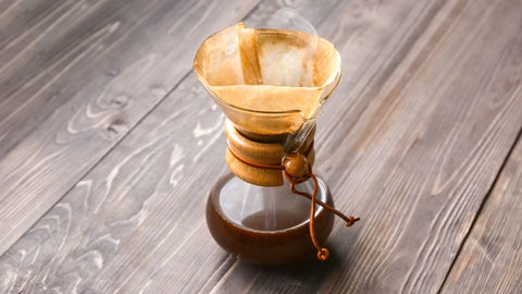A Chemex coffee maker with a glass carafe and wooden collar