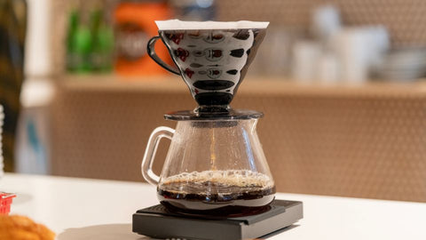 A Hario V60 coffee maker with a glass carafe and paper filter