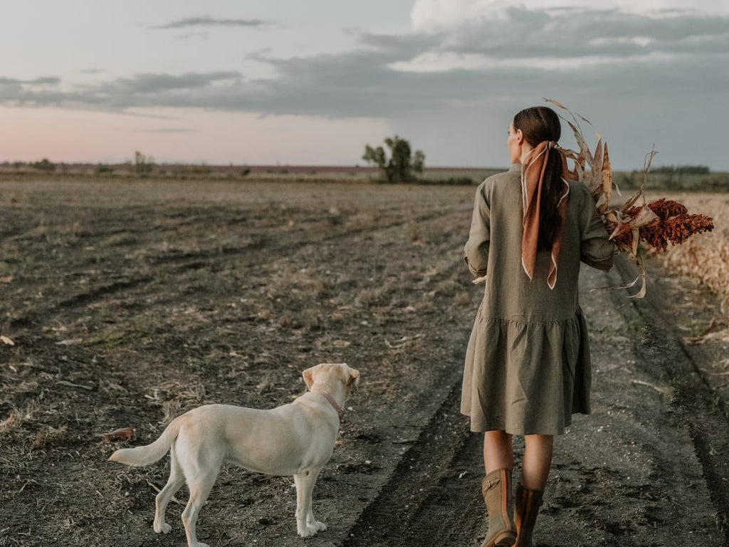 Grace Quast walk down a farm with a dog during sunset