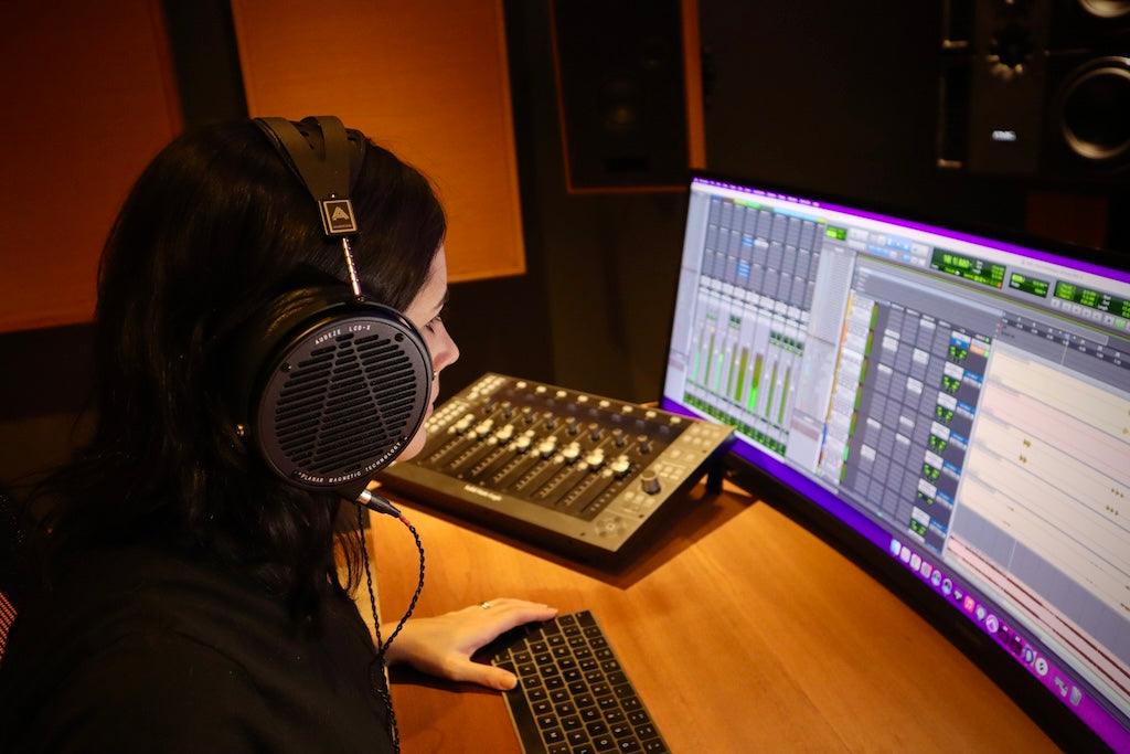Maria wearing LCD-X headphones while mixing