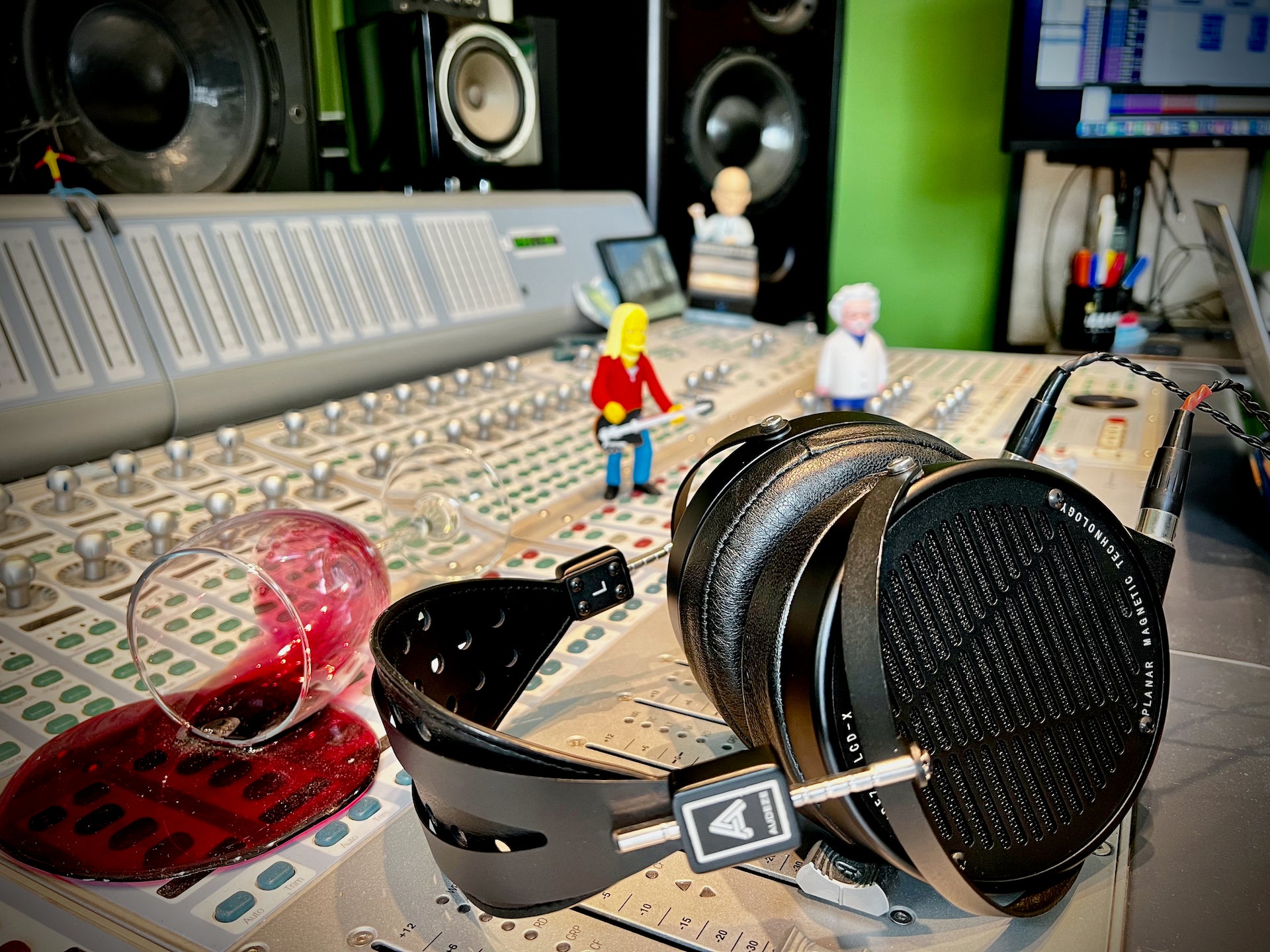 Audeze LCD-X headphones on mixing table with *fake* spilt wine and action figure