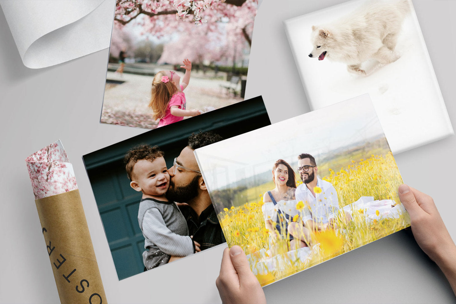 Person holding a high-quality photo print by Posterjack with more prints in the background.