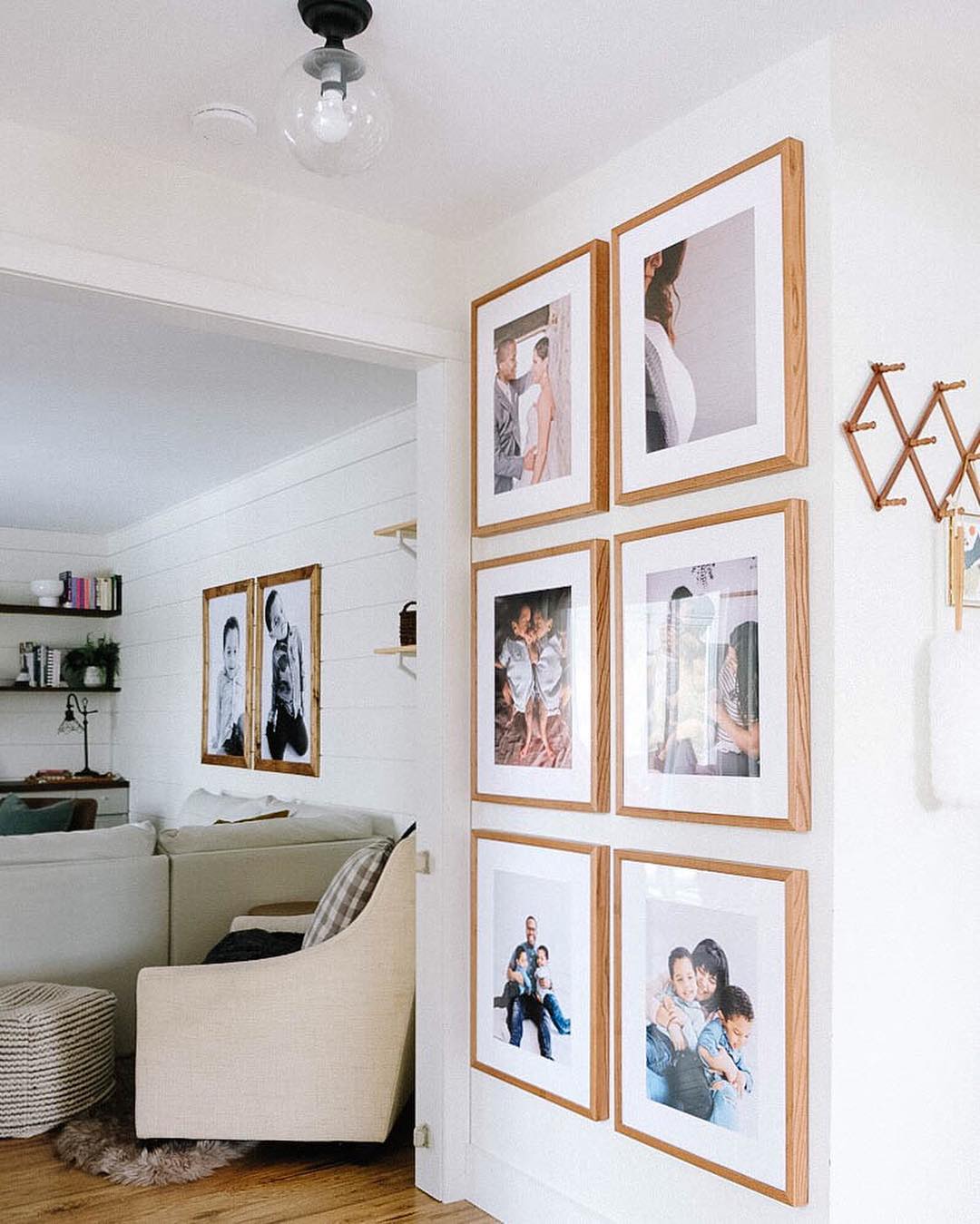 Gallery wall of family photos in Posterjack Light Walnut Gallery Frames. Image credit: Thalita Murray