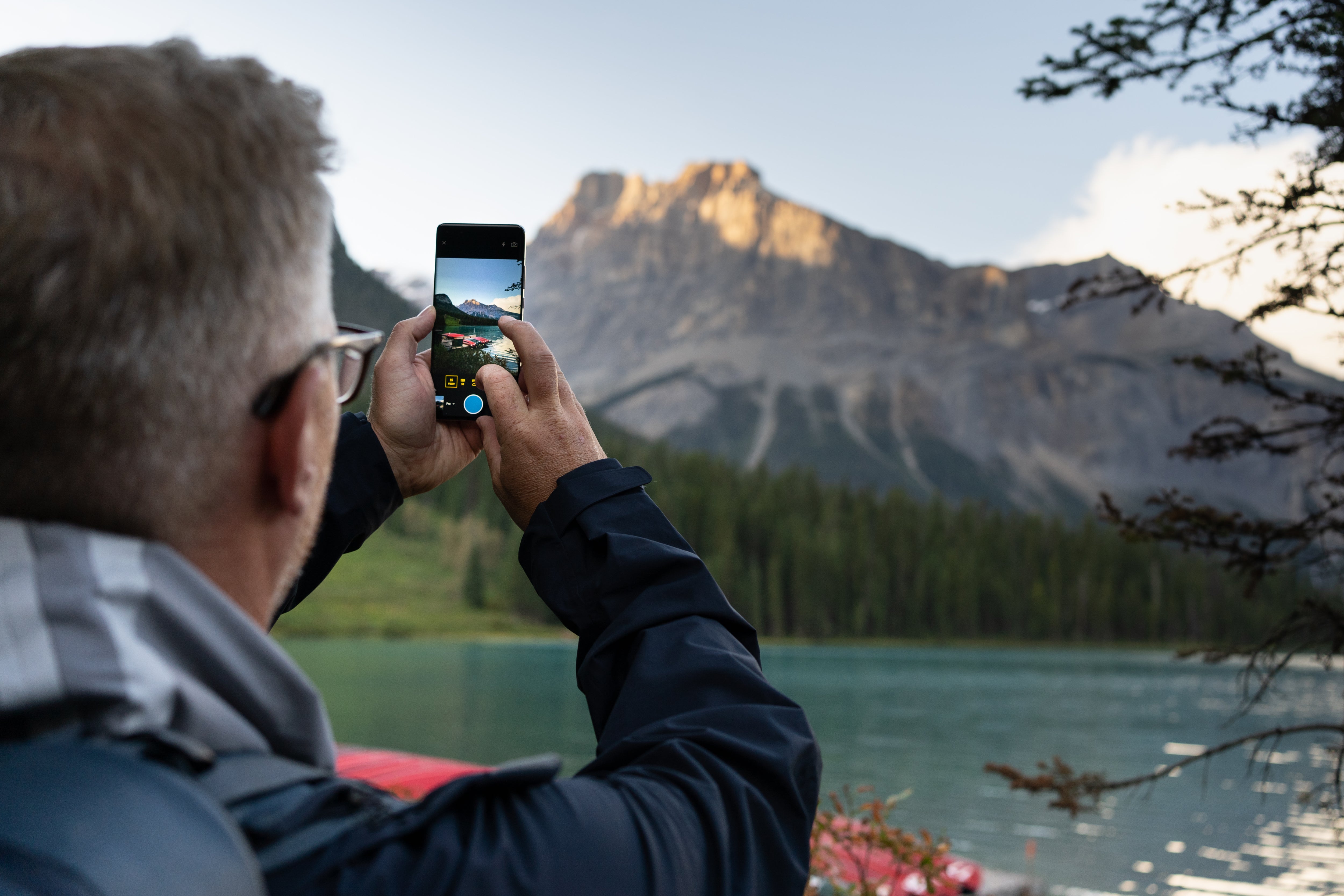 Man Taking a Photo of a Canadian Landscape Using His Smartphone