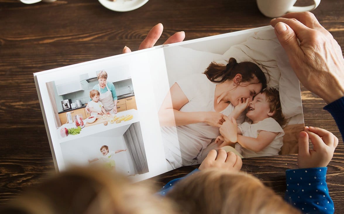 Adult and child looking at a custom photo book printed by Posterjack