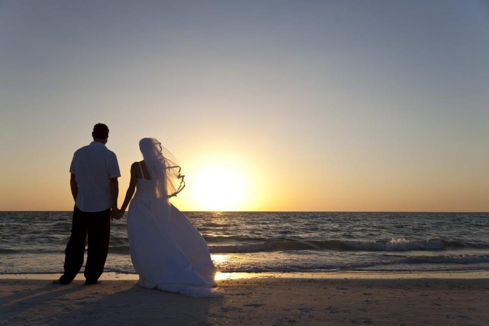 Using leading lines in wedding photography - photo of a bride and groom on the beach at sunset