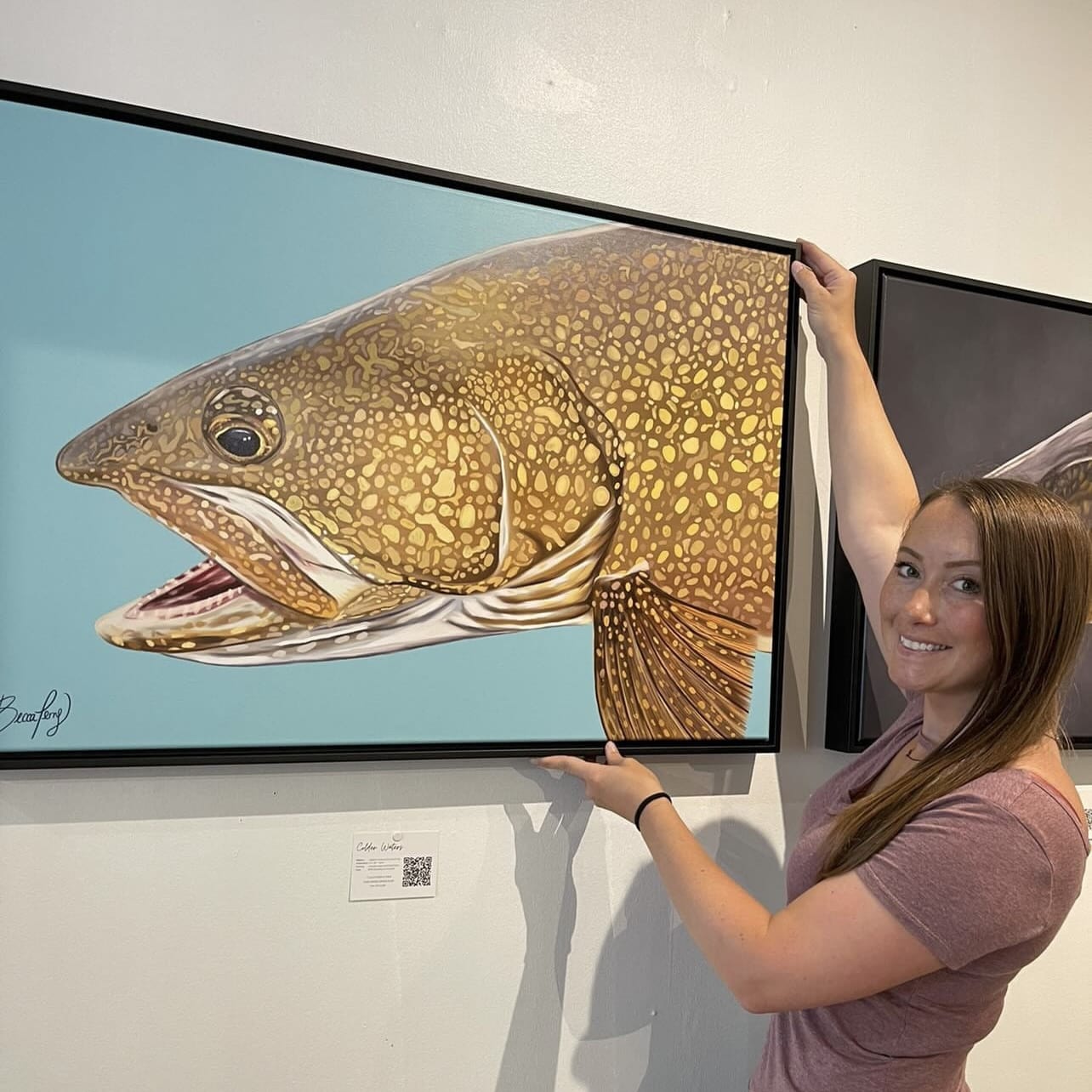 Canadian artist, Becca Perry, standing with her Posterjack Canvas Print of her original painting.