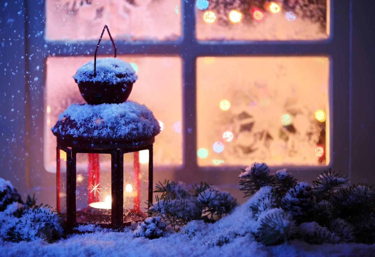 Snowy lantern outside a window - example of low-light photography without a camera's flash