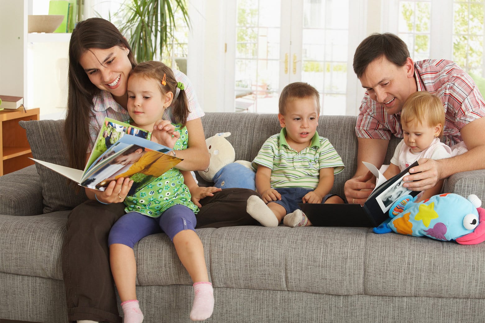 Family looking at photo books together in the living room.