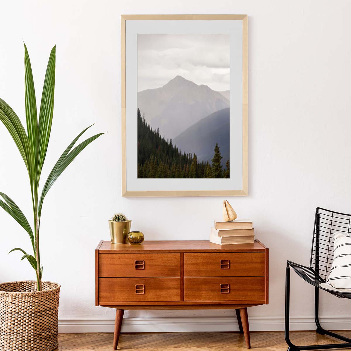 Black and white mountain landscape photo displayed in a natural wood picture frame in a living room.