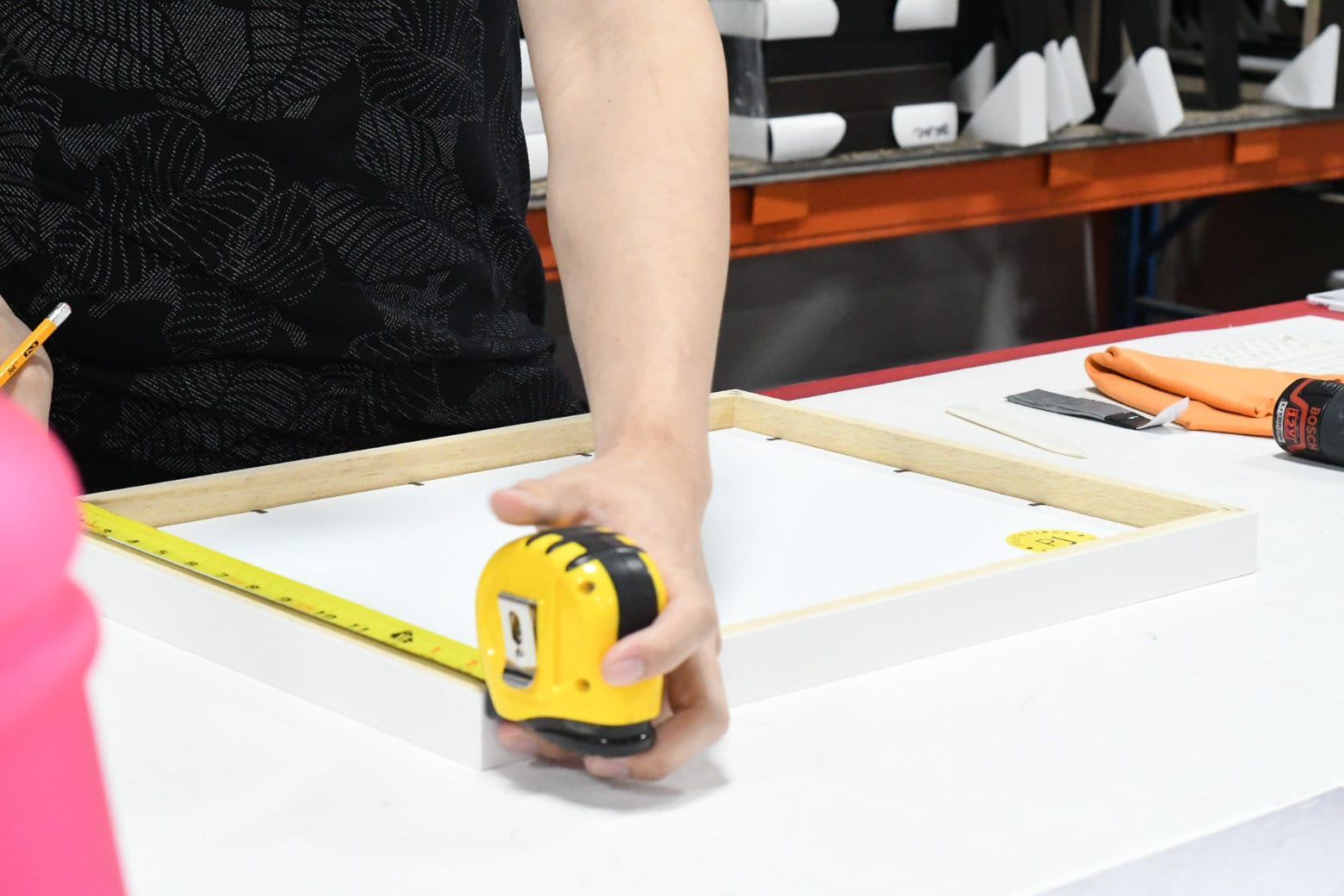 Behind-The-Scenes Inside the Posterjack Print Shop - Person Measuring a Custom Frame