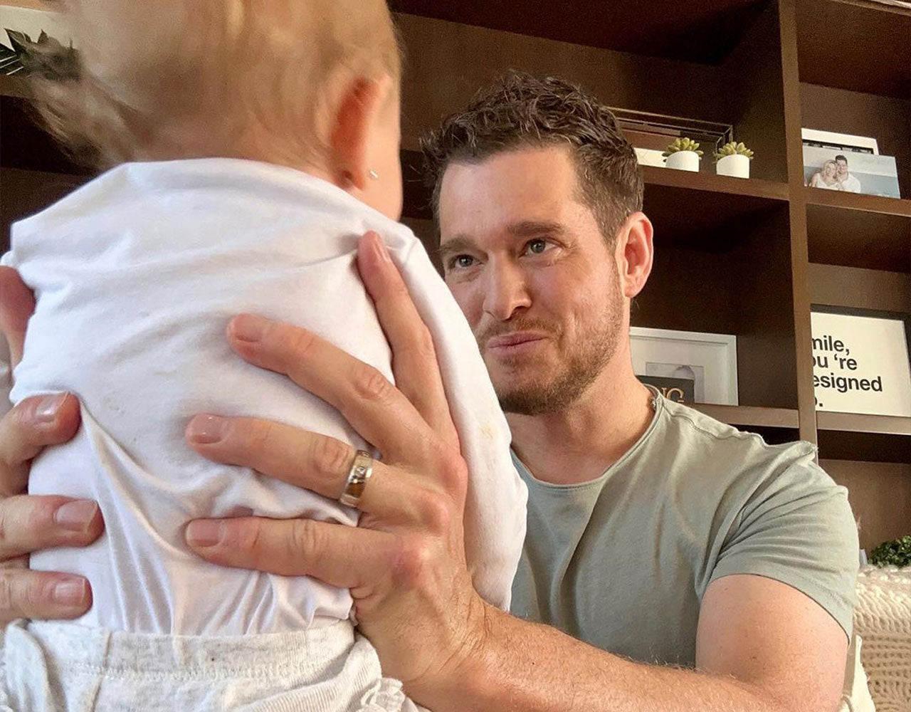 Michael Bublé holding a baby wearing his engagement ring