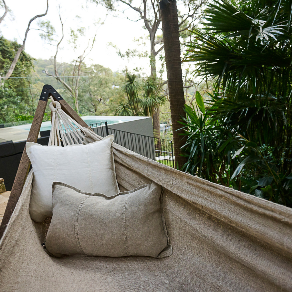 linen handwoven hammock accompained by outdoor linen cushions in neutrals