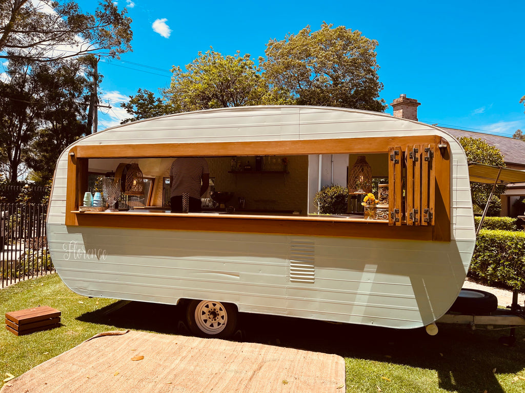 florence the cockatil caravan serving drinks out of the timber and sea mist coloured van