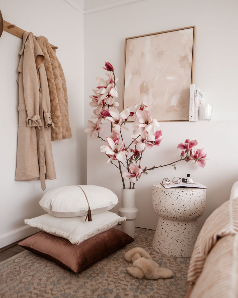 A linen cushion and velvet cushion stack in a stylish corner of the bedroom