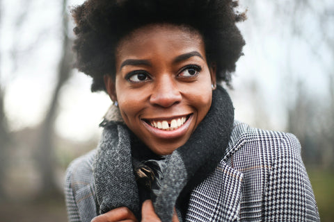 Woman wearing a houndstooth coat with a big smile. 