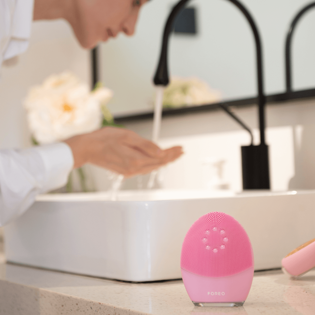 Woman cleansing face with FOREO Luna 4 plus device.