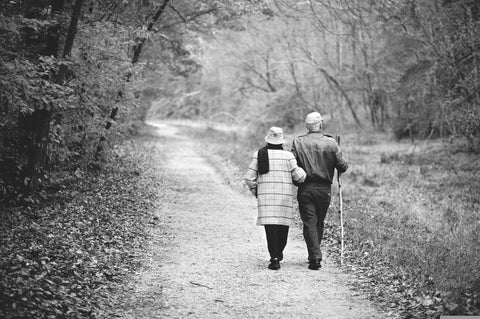 Proche aidant qui prend une marche avec un patient atteint de la maladie d'Alzheimer.