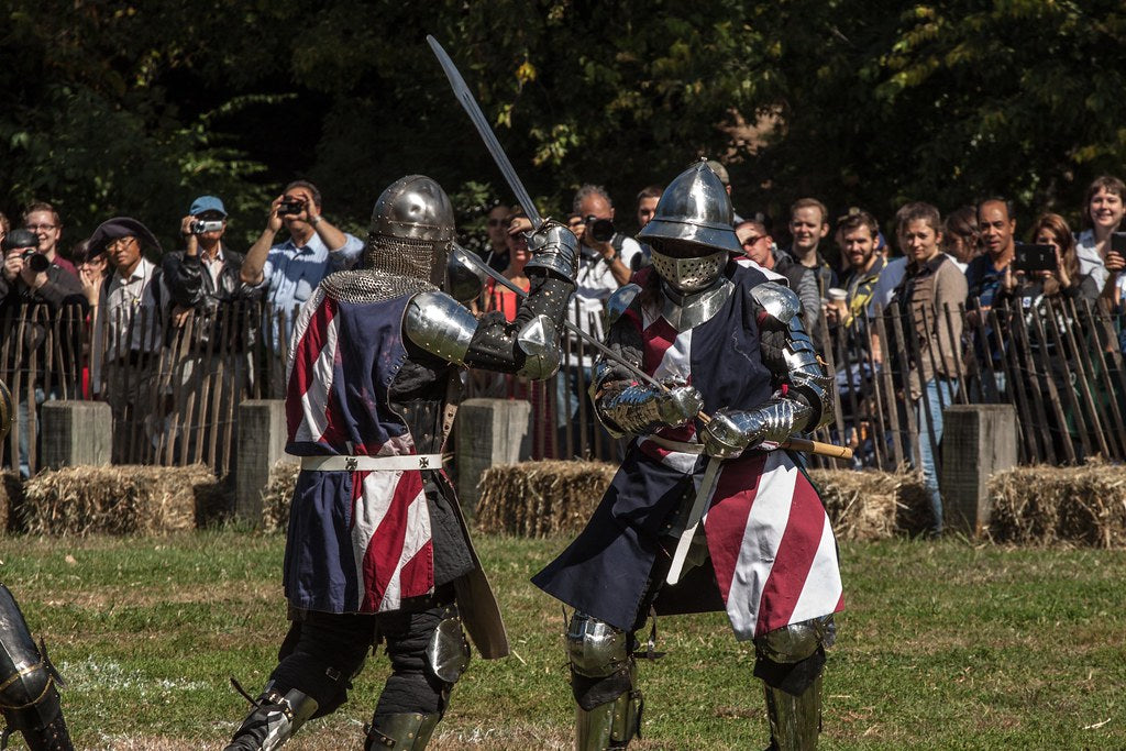 Two knight in metal armor fighting with a sword