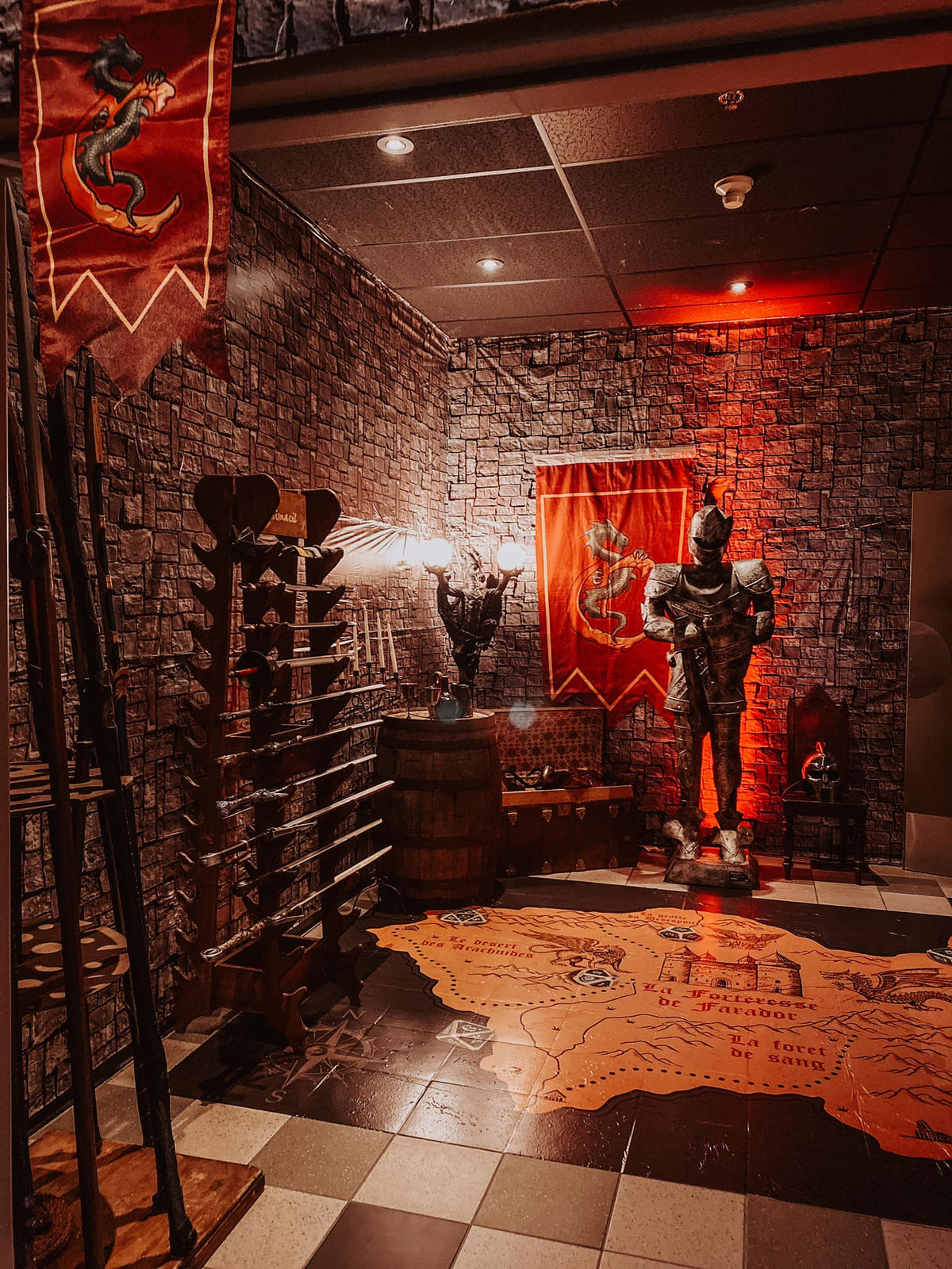 L'entrée de la salle de cinéma avec une carte au sol, des armes et une armure