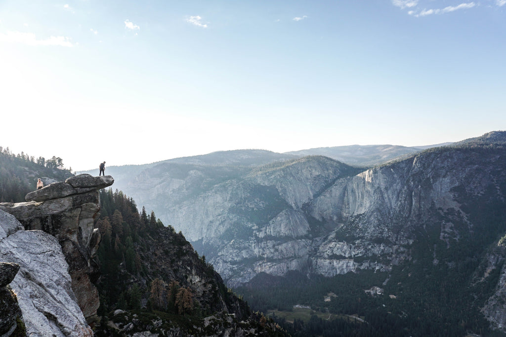 Hikers on ledge overlooking Glacier Point. Photo by Nathan Shipps on Unsplash
