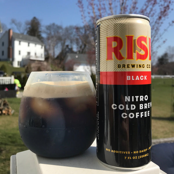 RISE nitro cold brew coffee -- organic, non-GMO, sustainably-sourced beverage in a can and in a glass -- on a farm