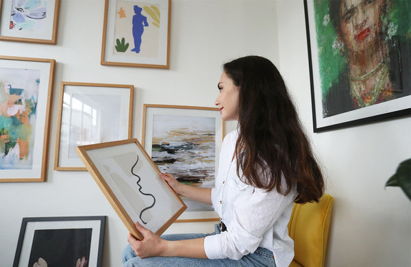 woman holding framed artwork