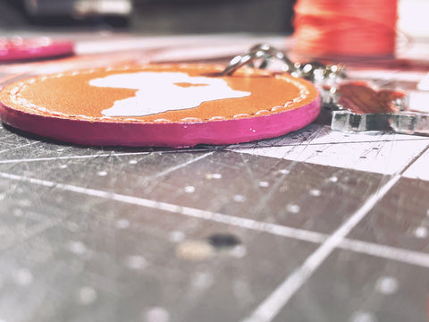 Edge painted in rose color with gloss top coat on the Africa Hand Stitched Keychain. 