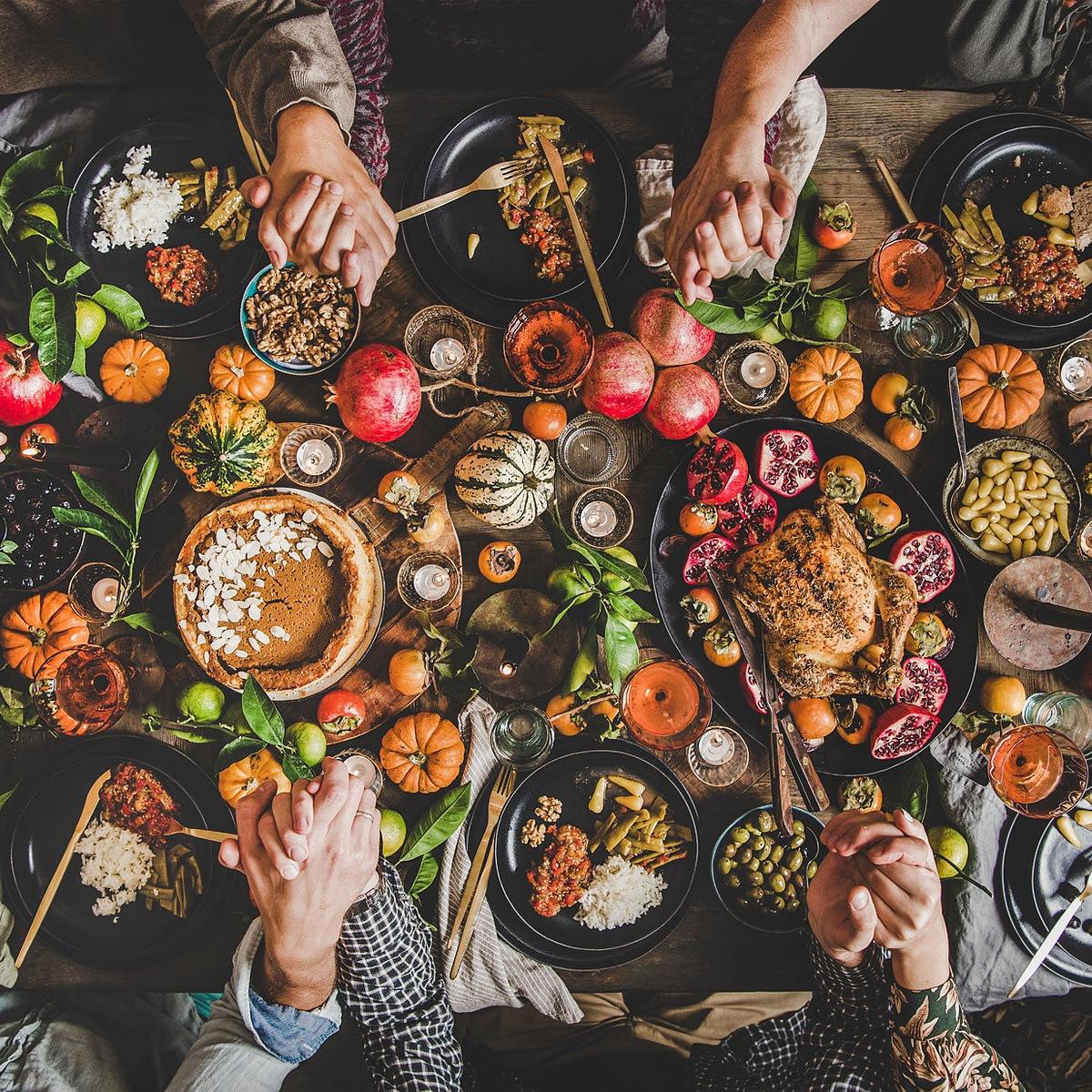 Hands being held around a Holiday Meal