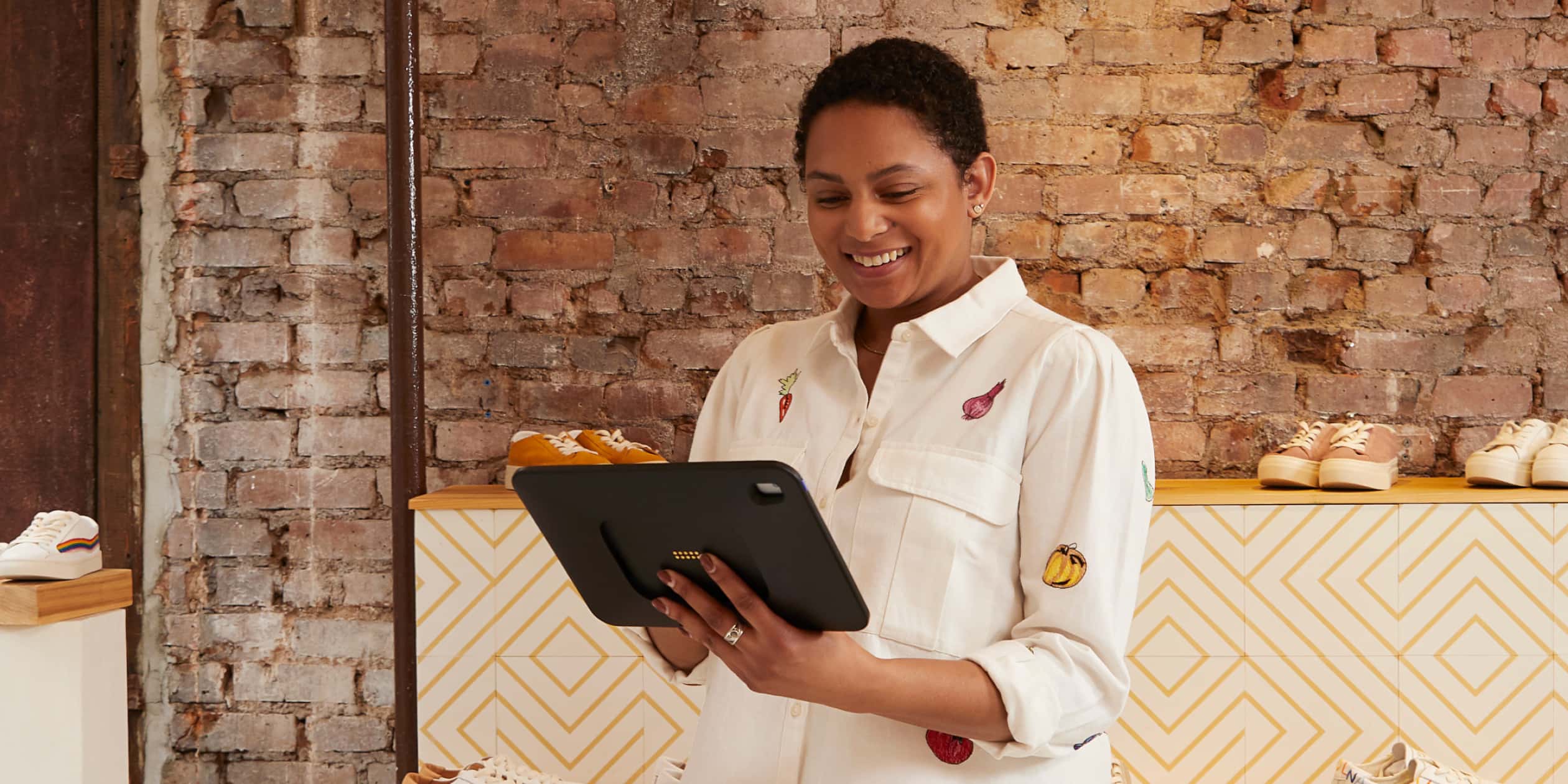 A store associate holds a POS tablet.