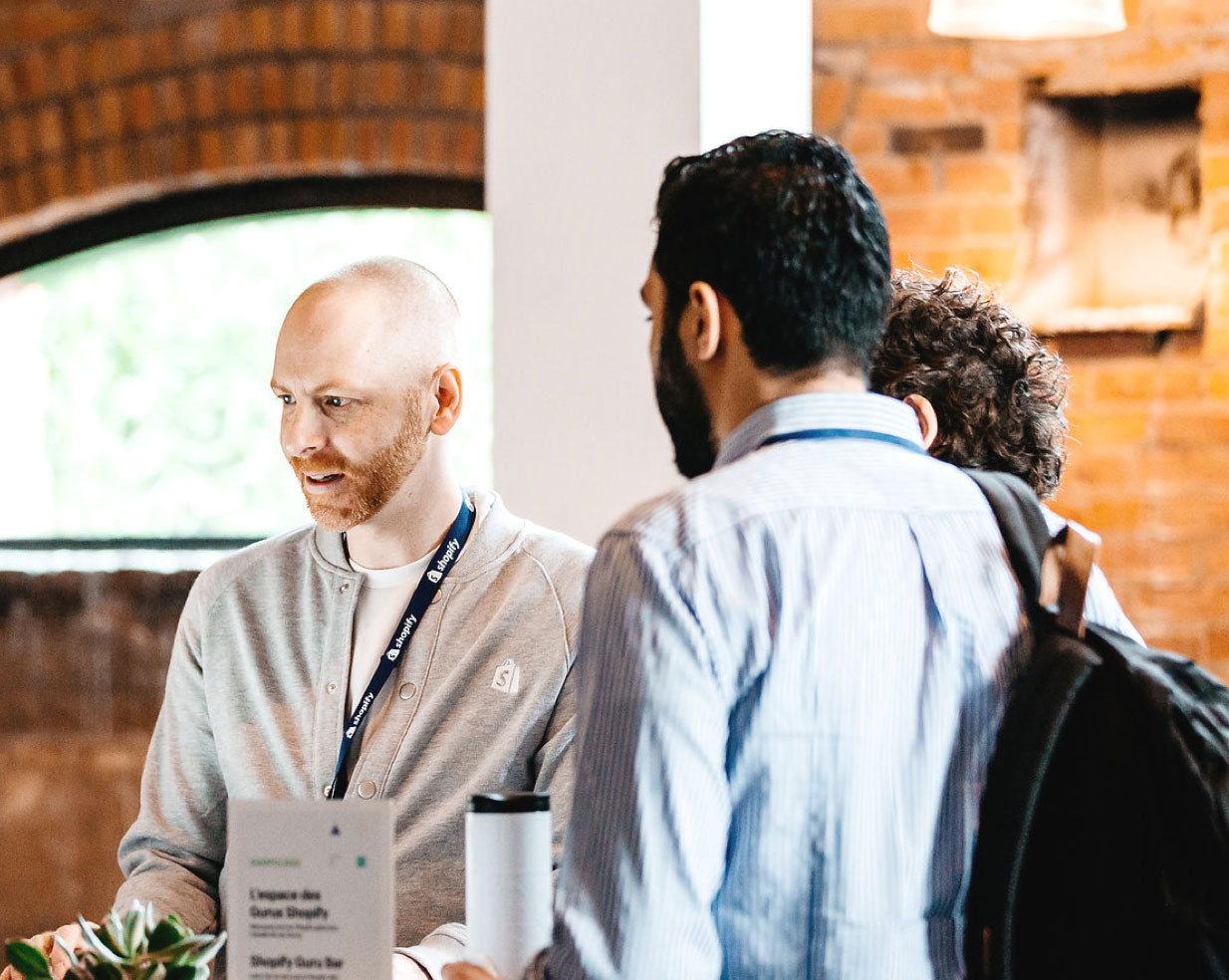 A Shopify employee talking to two prospective merchants